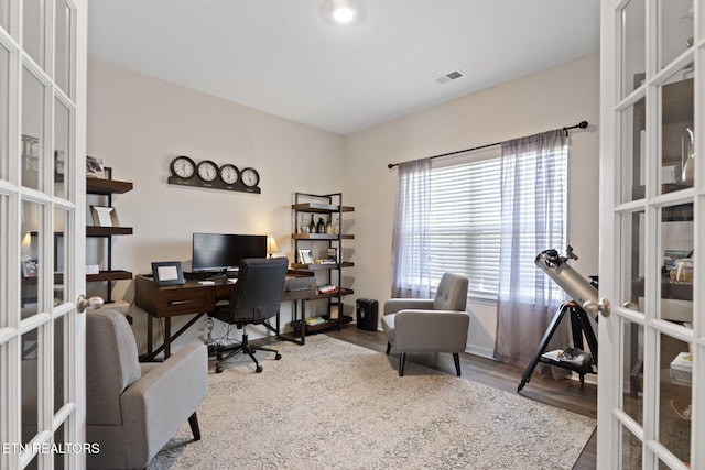 office featuring french doors, baseboards, visible vents, and wood finished floors