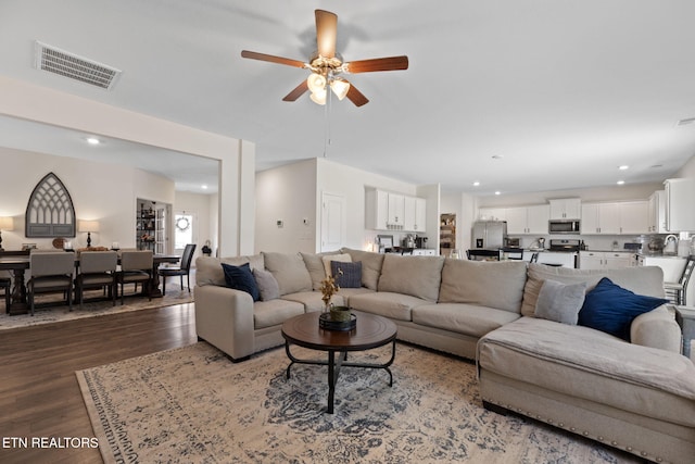 living area featuring recessed lighting, visible vents, dark wood-style flooring, and a ceiling fan