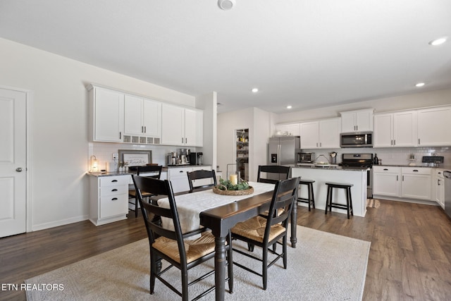 dining room with recessed lighting, dark wood-style flooring, a toaster, and baseboards