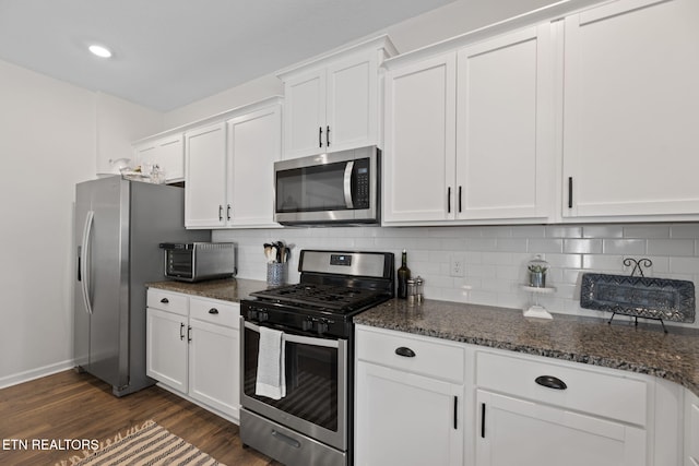 kitchen with baseboards, white cabinetry, dark wood-type flooring, decorative backsplash, and stainless steel appliances