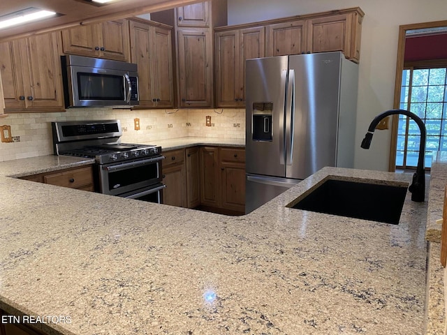 118 Mohawk Rd, Oak Ridge, TN 37830 - kitchen featuring a sink, tasteful backsplash, light stone counters, and stainless steel appliances