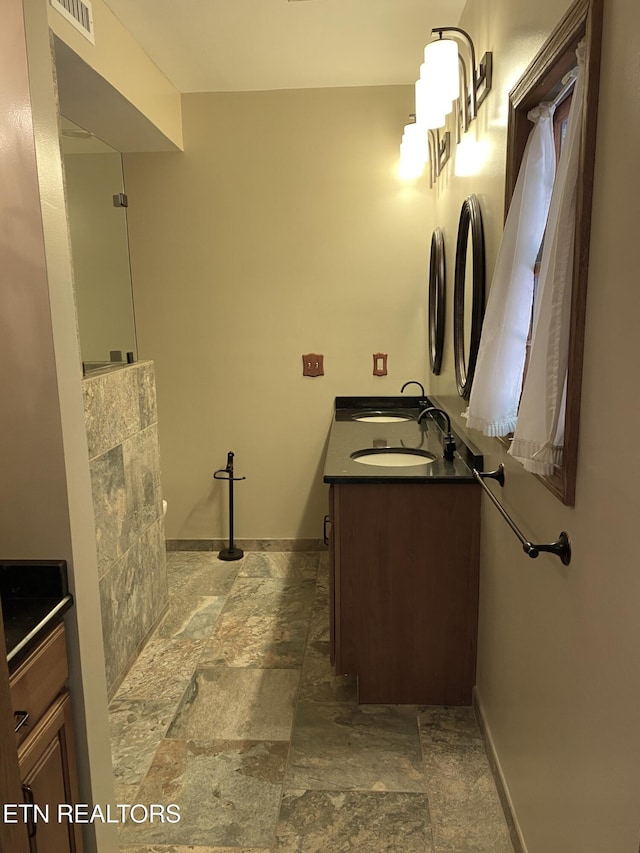 118 Mohawk Rd, Oak Ridge, TN 37830 - full bathroom featuring baseboards, visible vents, stone tile floors, and double vanity