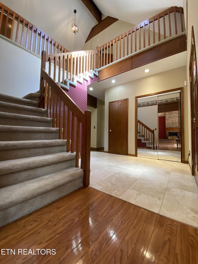 118 Mohawk Rd, Oak Ridge, TN 37830 - stairway featuring high vaulted ceiling, beamed ceiling, a stone fireplace, recessed lighting, and wood-type flooring