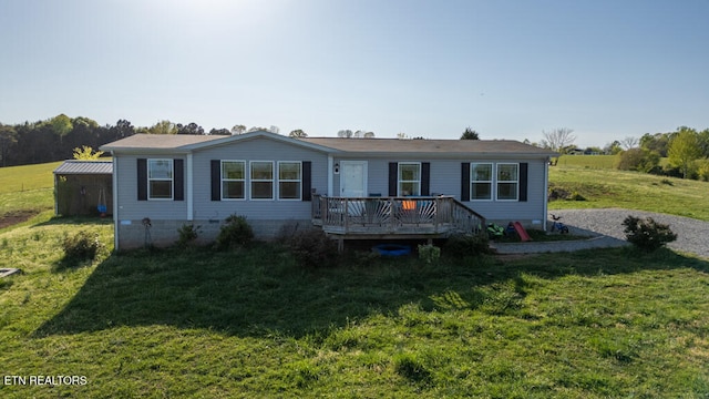 manufactured / mobile home featuring a deck and a front lawn