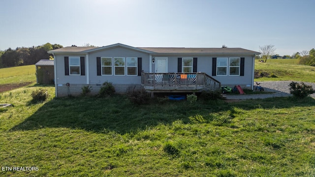 manufactured / mobile home with a front lawn and a wooden deck