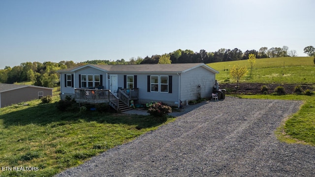 manufactured / mobile home featuring a front yard, gravel driveway, crawl space, and a wooden deck