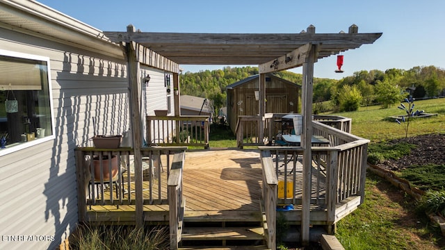 wooden deck with an outbuilding, a storage shed, and a pergola