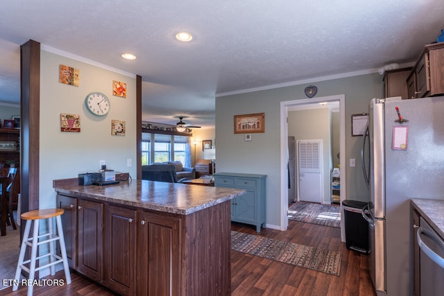 kitchen with dark wood-style floors, a textured ceiling, a ceiling fan, dark countertops, and stainless steel appliances