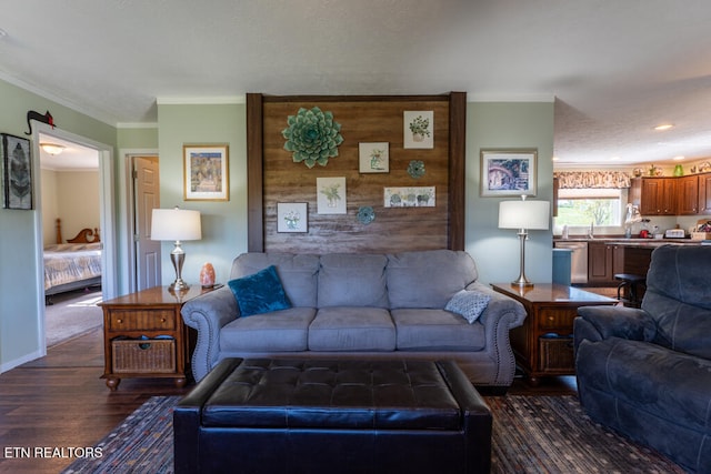 living room with dark wood-style flooring and ornamental molding