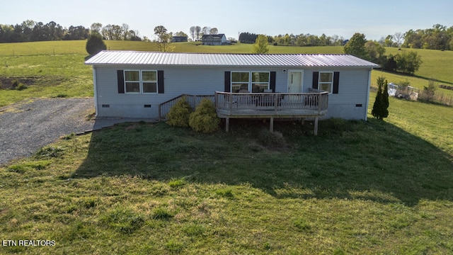view of front facade with metal roof, crawl space, a front lawn, a wooden deck, and a rural view