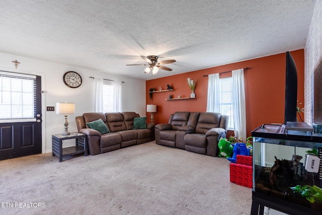 living room featuring ceiling fan, carpet flooring, and a textured ceiling