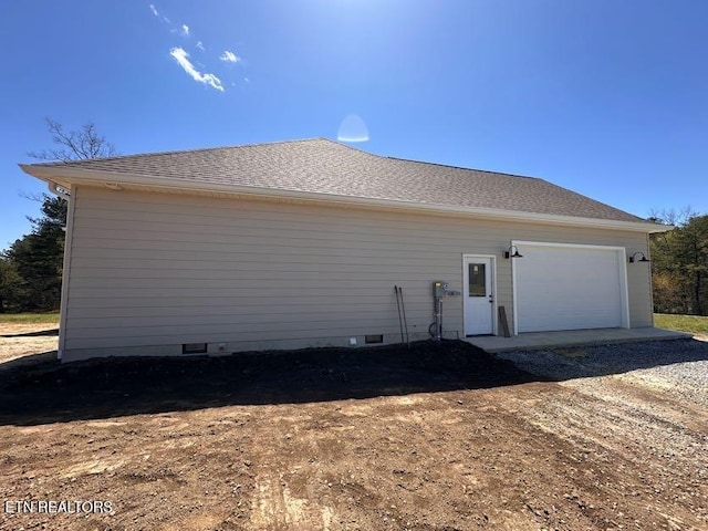 view of side of property featuring a garage and crawl space