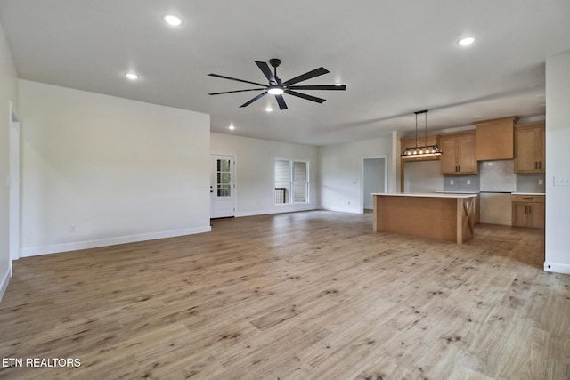 unfurnished living room with recessed lighting, baseboards, a ceiling fan, and light wood finished floors