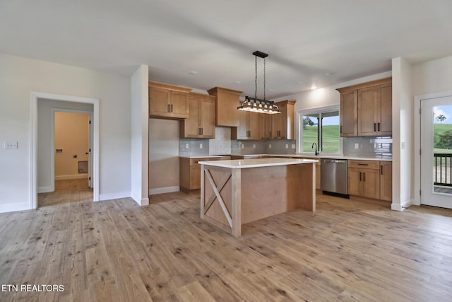 kitchen with stainless steel dishwasher, decorative backsplash, a kitchen island, light wood-type flooring, and light countertops