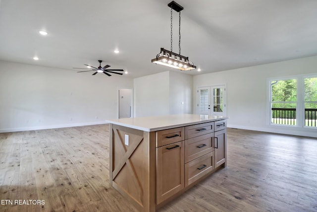 kitchen featuring french doors, a center island, baseboards, open floor plan, and light wood-type flooring