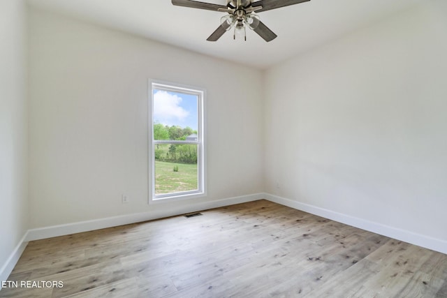 spare room with ceiling fan, baseboards, visible vents, and wood finished floors