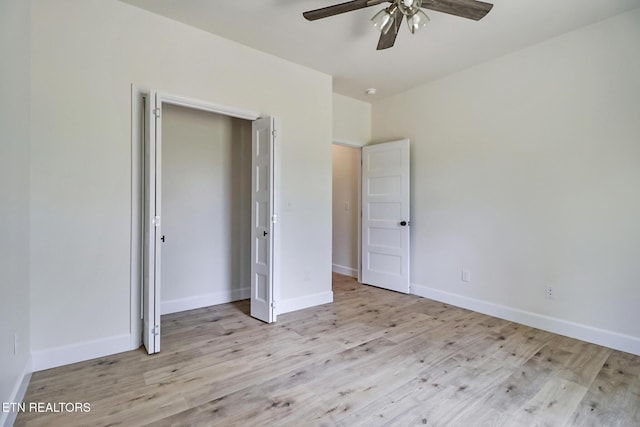 unfurnished bedroom with baseboards, a ceiling fan, a closet, and wood finished floors