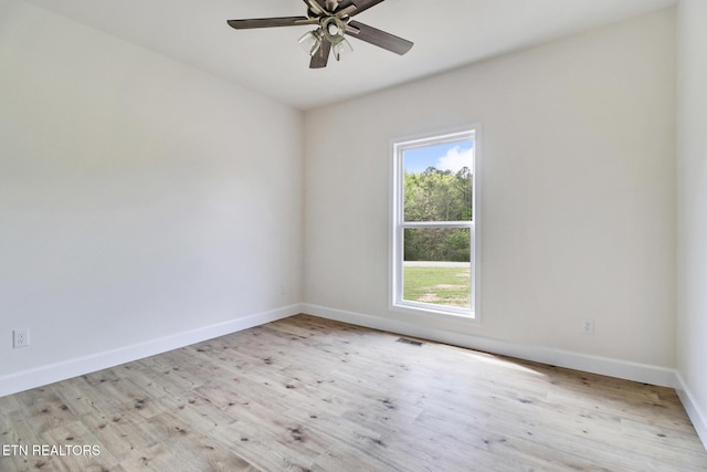 unfurnished room with baseboards, ceiling fan, a healthy amount of sunlight, and wood finished floors
