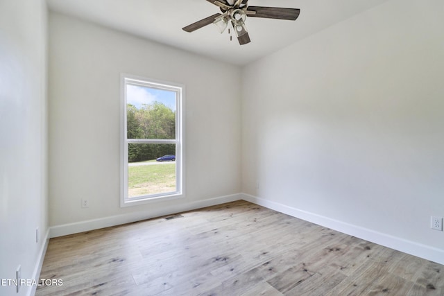unfurnished room with a healthy amount of sunlight, baseboards, and wood finished floors