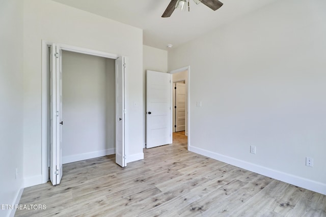 unfurnished bedroom featuring light wood-type flooring, a ceiling fan, and baseboards