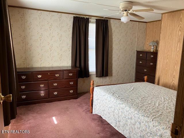 bedroom featuring carpet, wallpapered walls, and ceiling fan