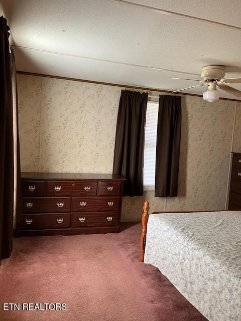 bedroom with wallpapered walls, a ceiling fan, and carpet