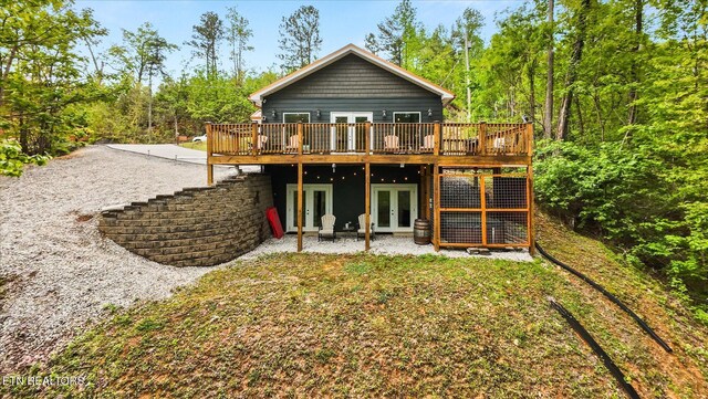 back of house featuring a wooden deck, a patio, and french doors