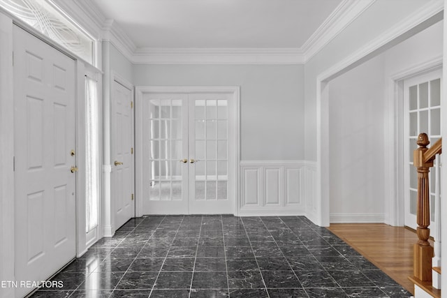 entrance foyer with marble finish floor, ornamental molding, and french doors