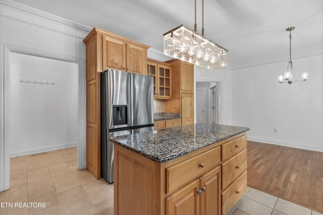 kitchen featuring ornamental molding, light tile patterned flooring, a kitchen island, stainless steel fridge, and a notable chandelier