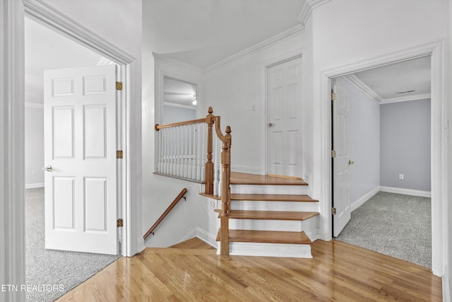 stairs featuring baseboards, ornamental molding, and wood finished floors
