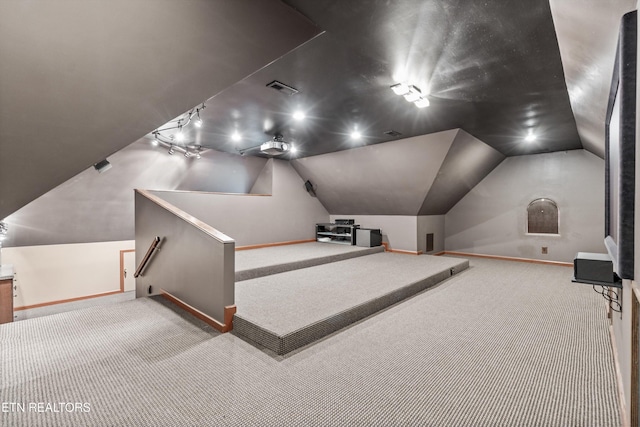carpeted cinema with baseboards, lofted ceiling, and visible vents