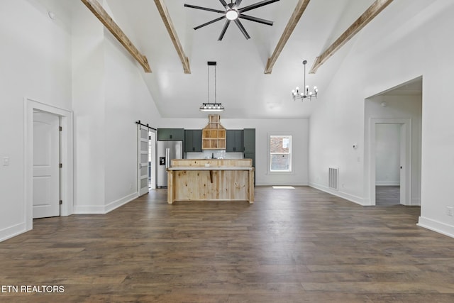 kitchen with stainless steel fridge, a barn door, high vaulted ceiling, and open floor plan