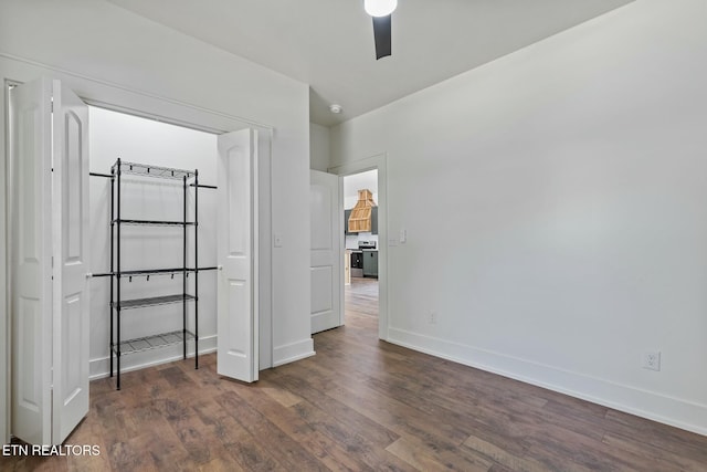unfurnished bedroom featuring baseboards, dark wood finished floors, and ceiling fan