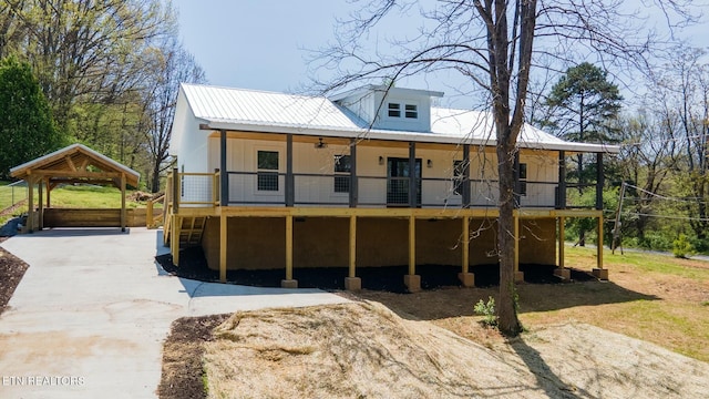 rear view of house featuring a carport, a ceiling fan, metal roof, and concrete driveway