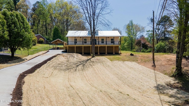 view of front of property featuring fence, a carport, concrete driveway, and a wooden deck