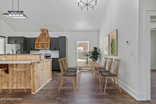 dining space featuring baseboards, dark wood-style flooring, a notable chandelier, and vaulted ceiling