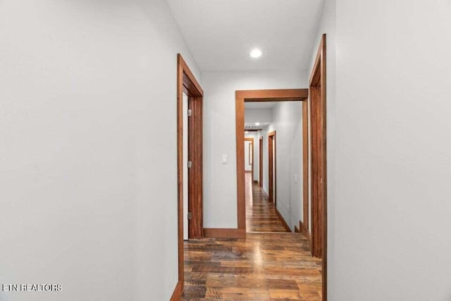 corridor featuring recessed lighting, wood finished floors, and baseboards