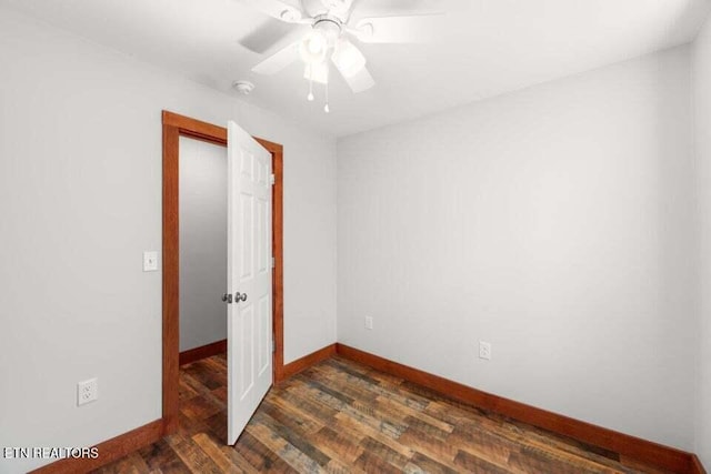 unfurnished bedroom featuring ceiling fan, baseboards, and dark wood-style flooring