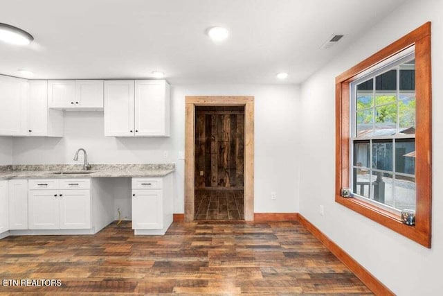 kitchen featuring visible vents, baseboards, dark wood-style flooring, and a sink