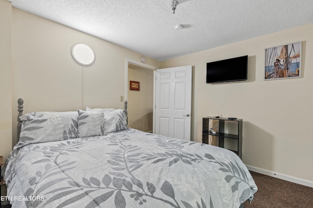 bedroom with carpet floors, a textured ceiling, and baseboards