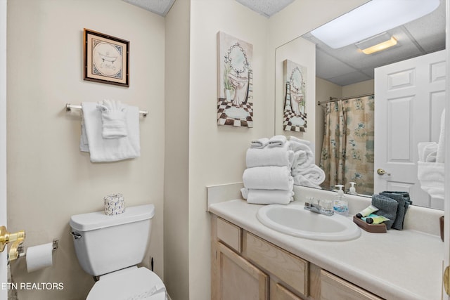 bathroom featuring toilet, vanity, and curtained shower