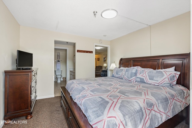 bedroom with connected bathroom, baseboards, and dark colored carpet