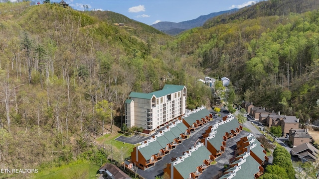 aerial view featuring a forest view and a mountain view