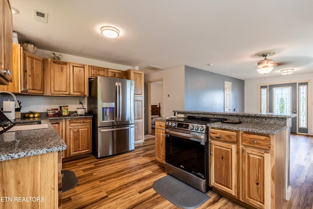537 Wilson St, Newport, TN 37821 - kitchen featuring dark stone counters, a sink, light wood finished floors, appliances with stainless steel finishes, and a kitchen island