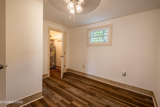 537 Wilson St, Newport, TN 37821 - empty room featuring baseboards, water heater, dark wood-style floors, and ceiling fan