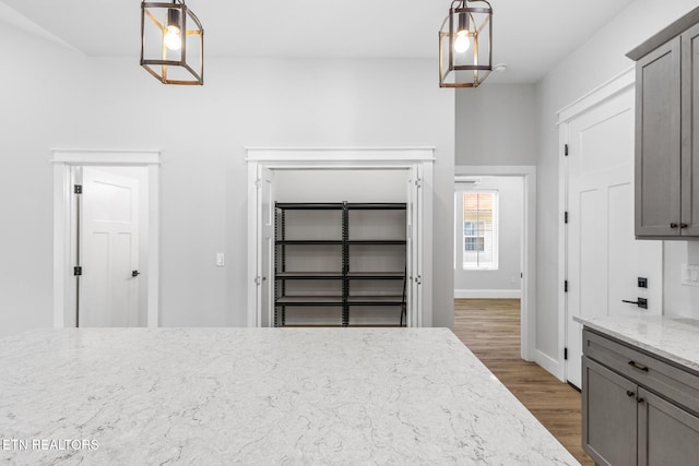 103 E Main St, Englewood, TN 37329 - kitchen featuring decorative light fixtures, light stone counters, gray cabinetry, and wood finished floors
