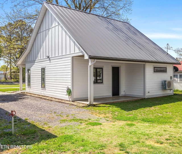 103 E Main St, Englewood, TN 37329 - rear view of house featuring board and batten siding, gravel driveway, metal roof, a lawn, and ac unit