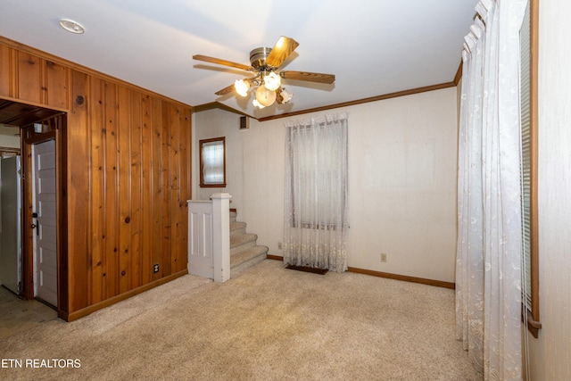 285 Telford St, Alcoa, TN 37701 - carpeted empty room featuring baseboards, ornamental molding, a ceiling fan, stairway, and wood walls