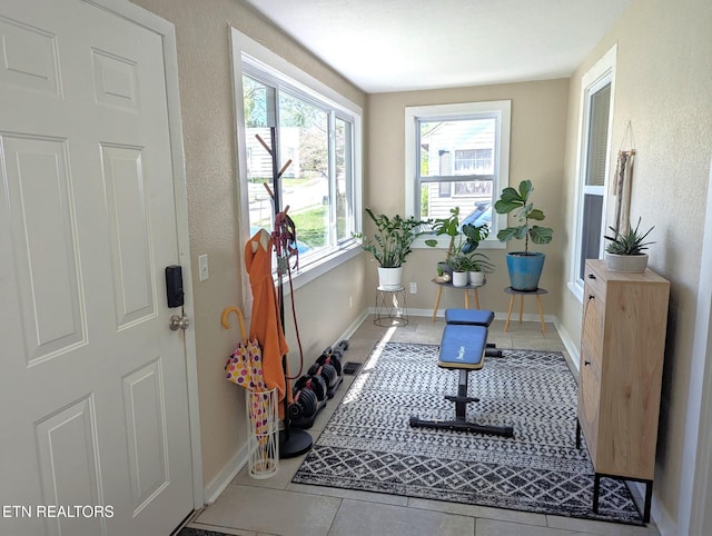 entryway with a textured wall, baseboards, and tile patterned flooring