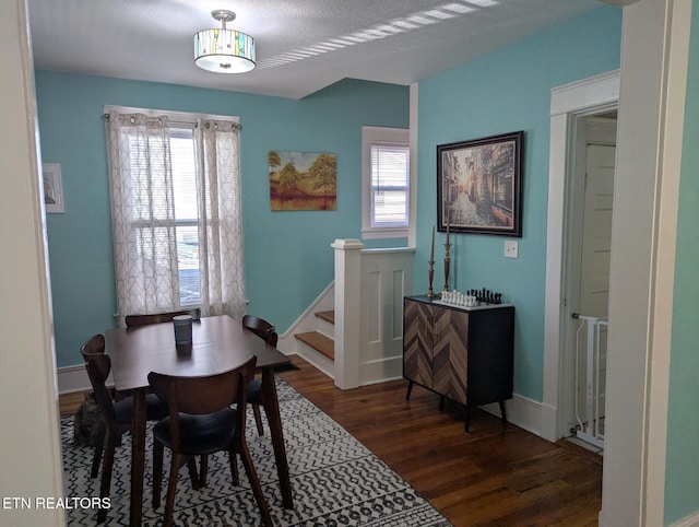 dining space with wood finished floors, baseboards, stairway, and a wealth of natural light